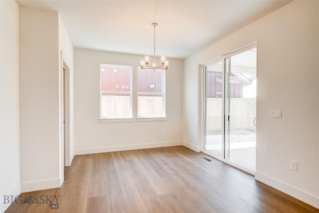 1520 Cyril Way, Belgrade, MT 59714 - unfurnished dining area with wood finished floors and a chandelier