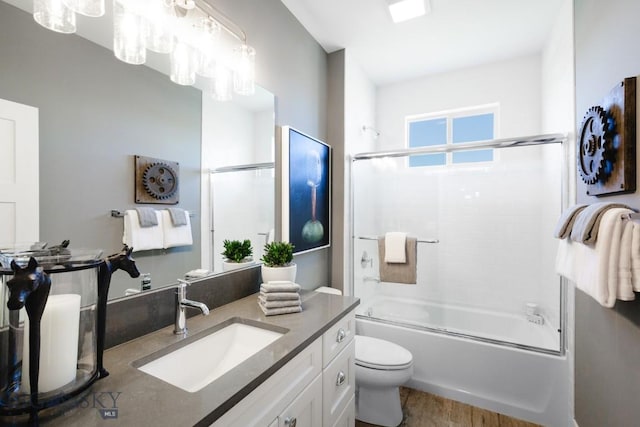 1202 Cody Way, Belgrade, MT 59714 - full bathroom featuring toilet, wood finished floors, enclosed tub / shower combo, and vanity