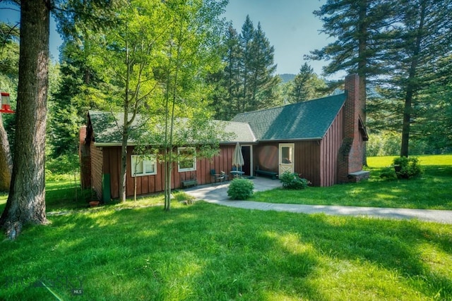 14470 Cottonwood Canyon Rd, Bozeman, MT 59718 - chalet / cabin with roof with shingles, a front lawn, a chimney, and board and batten siding