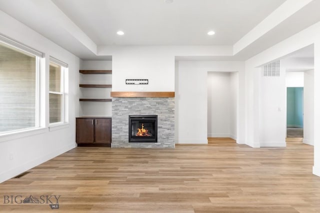 1511 Masterson, Belgrade, MT 59714 - unfurnished living room with a fireplace, visible vents, light wood finished floors, and baseboards