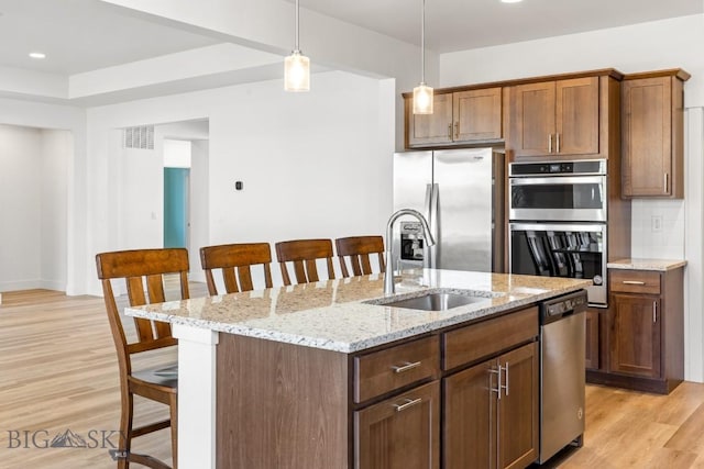 1511 Masterson, Belgrade, MT 59714 - kitchen with light wood finished floors, a sink, stainless steel appliances, a kitchen bar, and visible vents