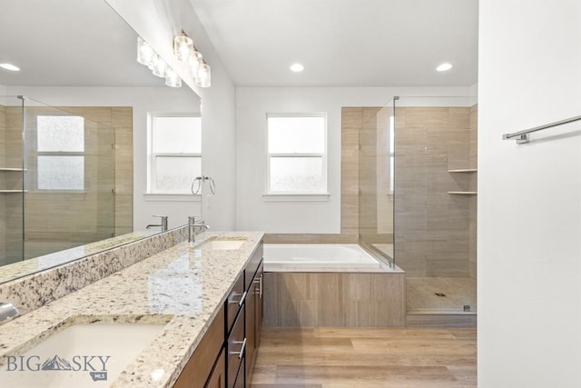 1511 Masterson, Belgrade, MT 59714 - full bathroom featuring double vanity, a bath, a shower stall, recessed lighting, and wood finished floors