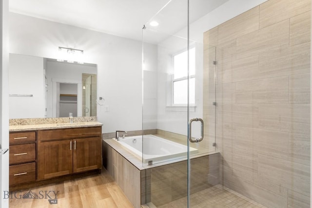 1511 Masterson, Belgrade, MT 59714 - bathroom featuring wood finished floors, a garden tub, vanity, and a stall shower