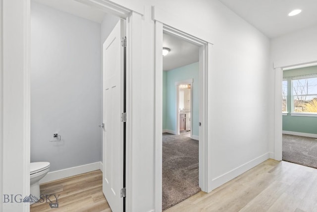 1511 Masterson, Belgrade, MT 59714 - hall with light carpet, light wood-style flooring, and baseboards