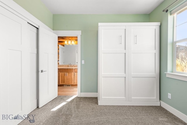 1511 Masterson, Belgrade, MT 59714 - unfurnished bedroom featuring baseboards, carpet floors, connected bathroom, and a closet