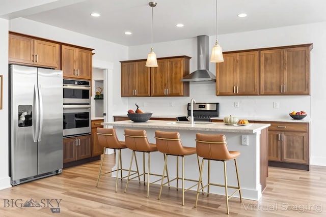 1511 Masterson, Belgrade, MT 59714 - kitchen featuring stainless steel appliances, wall chimney range hood, brown cabinets, light wood finished floors, and recessed lighting