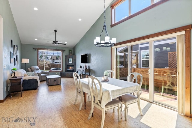 3383 Sora Way, Bozeman, MT 59718 - dining room with ceiling fan, healthy amount of natural light, light wood-style flooring, a tile fireplace, and high vaulted ceiling