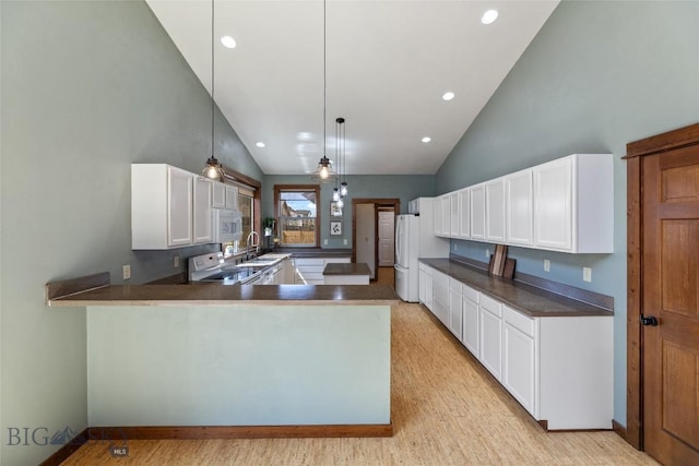 3383 Sora Way, Bozeman, MT 59718 - kitchen featuring white appliances, a peninsula, dark countertops, high vaulted ceiling, and white cabinetry