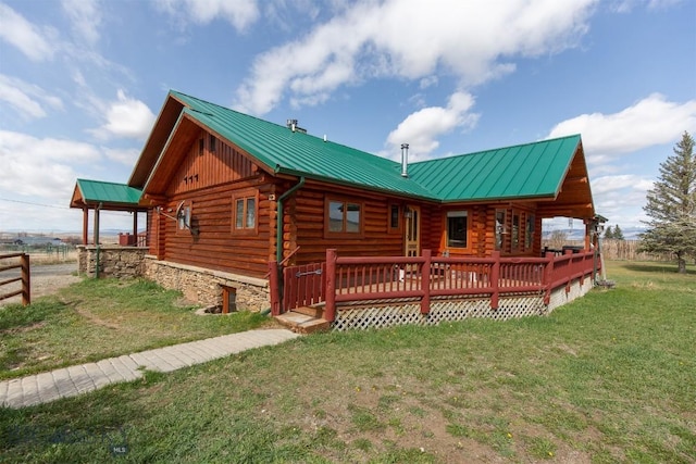 back of property with a standing seam roof, metal roof, and log exterior