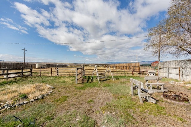view of yard featuring fence and a rural view