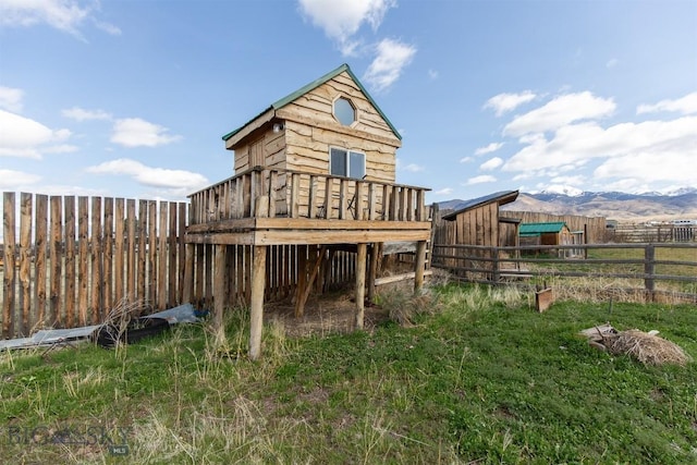 view of outdoor structure featuring a mountain view and a fenced backyard