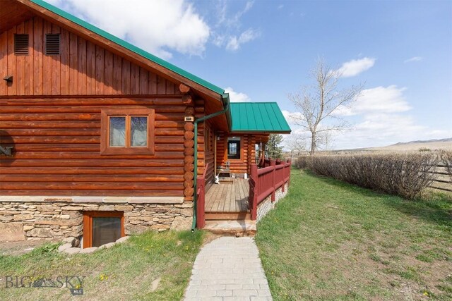 18 7m4r Rd, Sheridan, MT 59749 - view of side of property featuring log siding, a lawn, a metal roof, a wooden deck, and board and batten siding