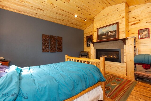 18 7m4r Rd, Sheridan, MT 59749 - bedroom with wooden ceiling, vaulted ceiling, wooden walls, wood finished floors, and a glass covered fireplace