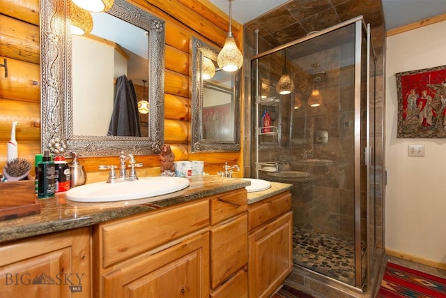 full bathroom with a stall shower, double vanity, log walls, and a sink