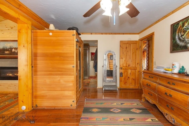 bedroom with wood finished floors, a ceiling fan, ornamental molding, and a sauna