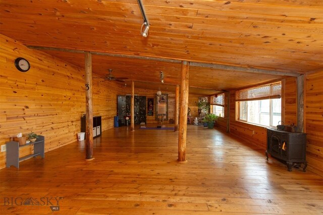 18 7m4r Rd, Sheridan, MT 59749 - unfurnished living room with a wood stove, wood walls, wood-type flooring, wood ceiling, and a ceiling fan