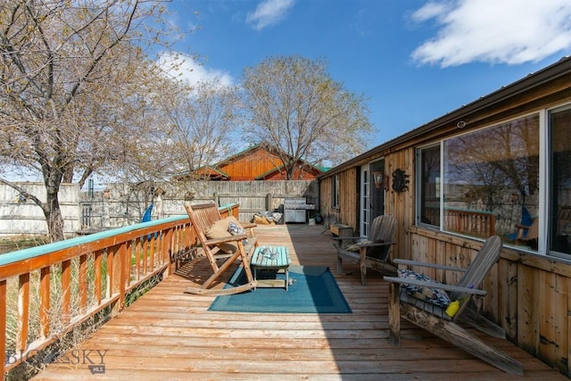 wooden deck featuring grilling area and a fenced backyard