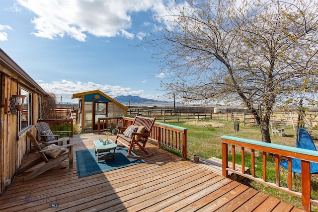 wooden terrace with a mountain view, an outdoor living space, a yard, and fence