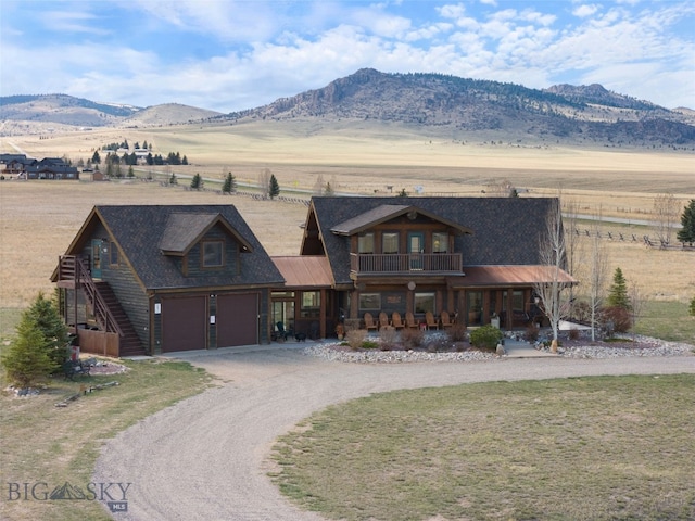 6 Browtine Ln, Ennis, MT 59729 - view of front of house featuring a porch, a garage, dirt driveway, a mountain view, and a balcony