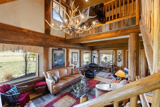 6 Browtine Ln, Ennis, MT 59729 - living room with a wealth of natural light, a towering ceiling, wood finished floors, and a notable chandelier
