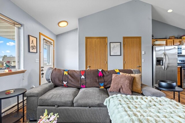 904 Jeanette Pl Unit 4, Belgrade, MT 59714 - living room featuring baseboard heating, wood finished floors, and vaulted ceiling