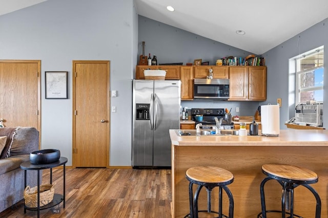904 Jeanette Pl Unit 4, Belgrade, MT 59714 - kitchen featuring brown cabinets, stainless steel appliances, a kitchen breakfast bar, light countertops, and wood finished floors