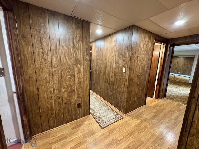 interior space featuring wood walls, wood finished floors, and baseboard heating