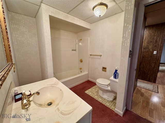 bathroom with toilet, tub / shower combination, vanity, and baseboards