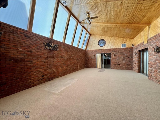 interior space featuring a ceiling fan, high vaulted ceiling, brick wall, and wood ceiling