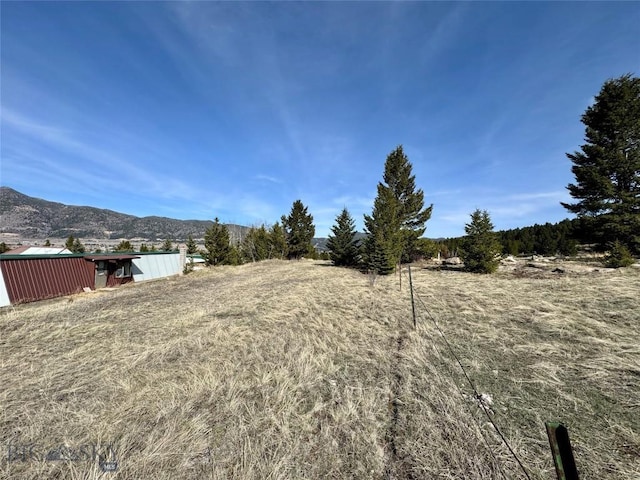 view of yard featuring a mountain view, a pole building, and an outbuilding