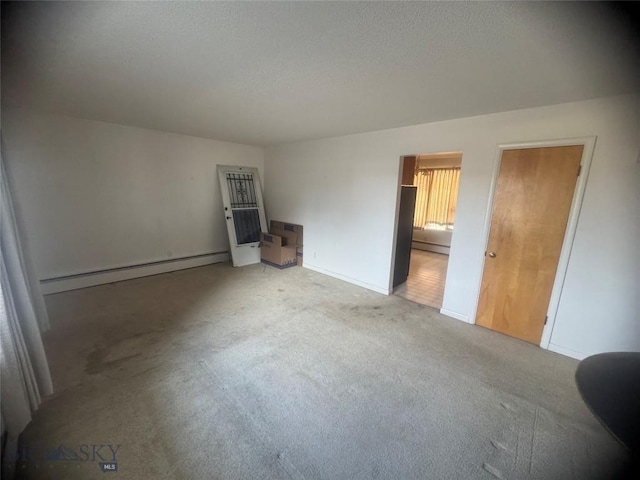 unfurnished bedroom featuring a textured ceiling, carpet flooring, a baseboard radiator, baseboard heating, and baseboards