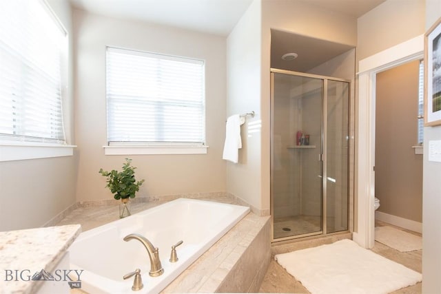 bathroom with toilet, a shower stall, plenty of natural light, and a bath