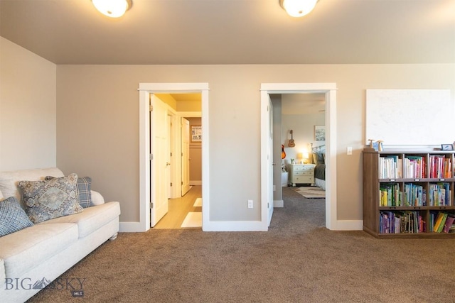 sitting room featuring carpet flooring and baseboards