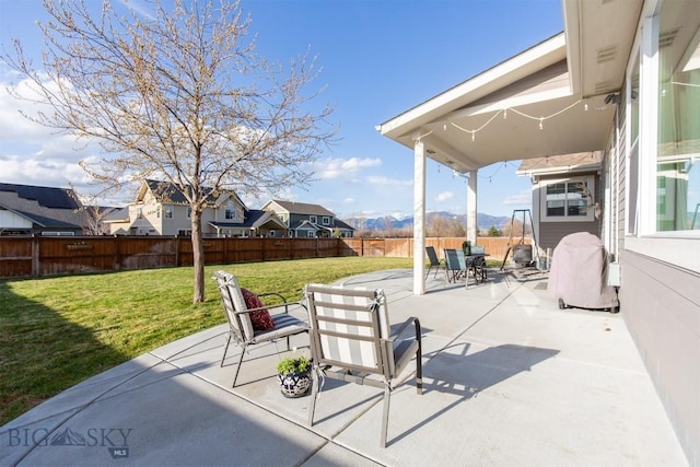 view of patio / terrace with outdoor dining space, a mountain view, and a fenced backyard