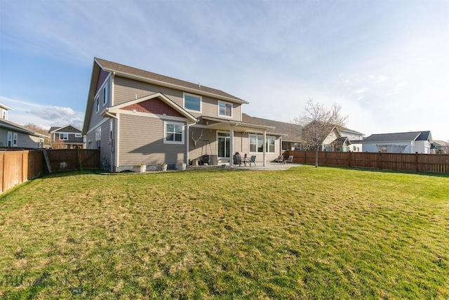 rear view of property with a patio, a yard, and a fenced backyard