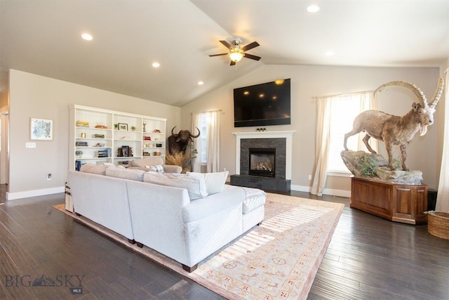 living room featuring a tile fireplace, ceiling fan, a wealth of natural light, and vaulted ceiling