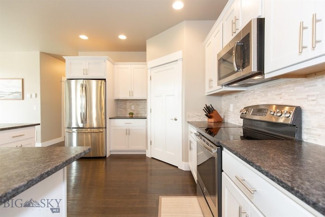 kitchen featuring white cabinets, dark countertops, appliances with stainless steel finishes, and decorative backsplash