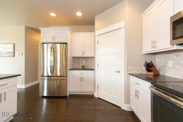 kitchen featuring appliances with stainless steel finishes, dark wood-type flooring, white cabinetry, and tasteful backsplash