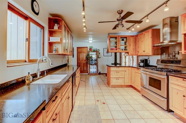 726 US Highway 10 W, Livingston, MT 59047 - kitchen with stainless steel gas stove, wall chimney exhaust hood, rail lighting, a sink, and ceiling fan