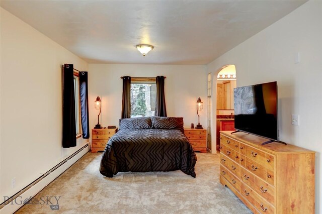 726 US Highway 10 W, Livingston, MT 59047 - bedroom with a baseboard radiator, arched walkways, light colored carpet, and ensuite bath