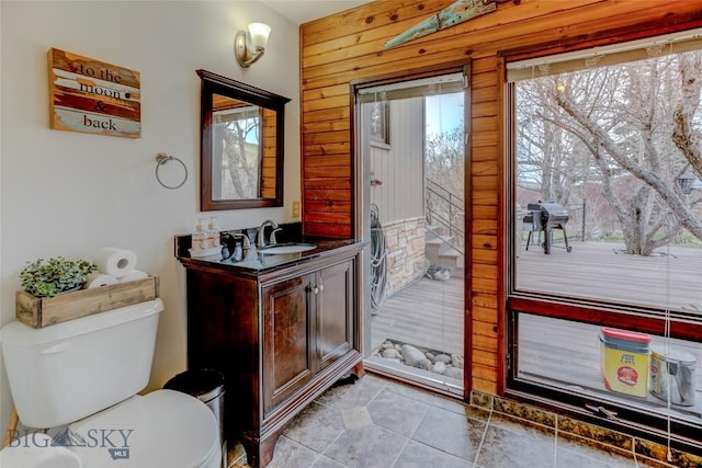 726 US Highway 10 W, Livingston, MT 59047 - bathroom with toilet, vanity, tile patterned flooring, and wood walls