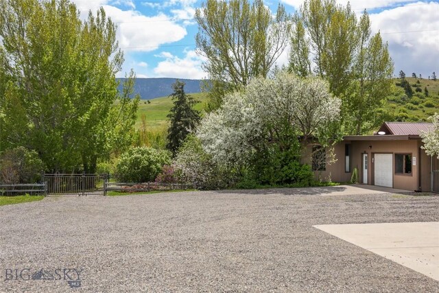 726 US Highway 10 W, Livingston, MT 59047 - view of yard featuring concrete driveway, an attached garage, and a mountain view