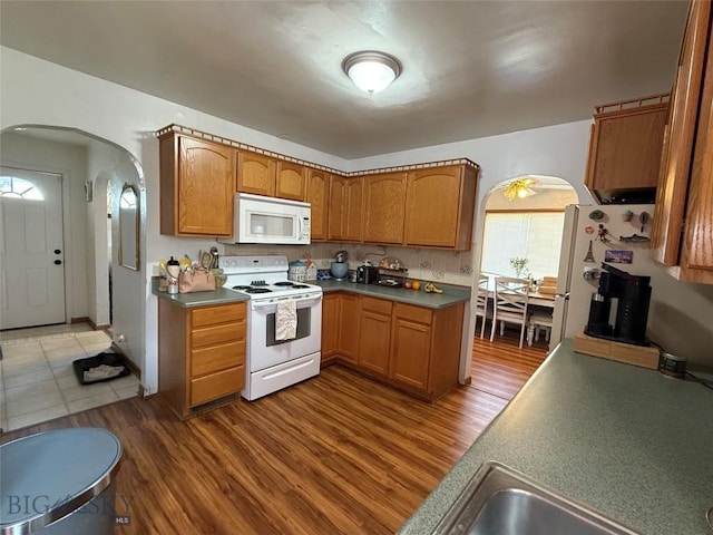 2900 Kennedy, Butte, MT 59701 - kitchen featuring arched walkways, brown cabinets, wood finished floors, and white appliances