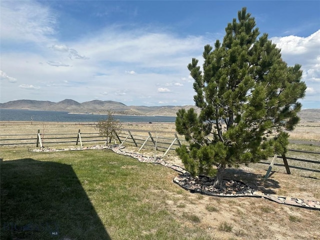 view of yard featuring fence, a rural view, and a mountain view