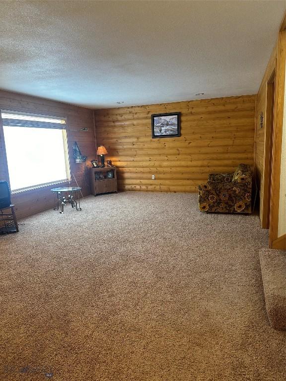 living area with a textured ceiling and carpet flooring