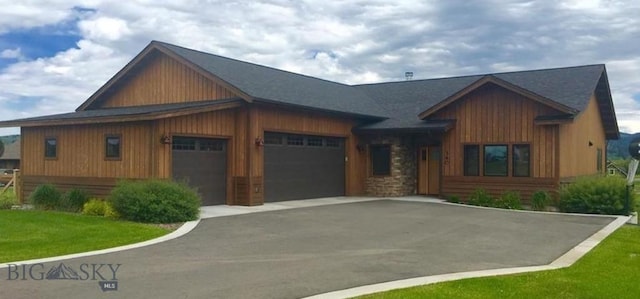 view of front of property featuring a front yard, driveway, and an attached garage