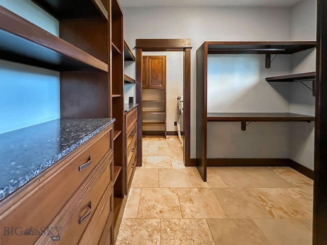 spacious closet with stone finish floor