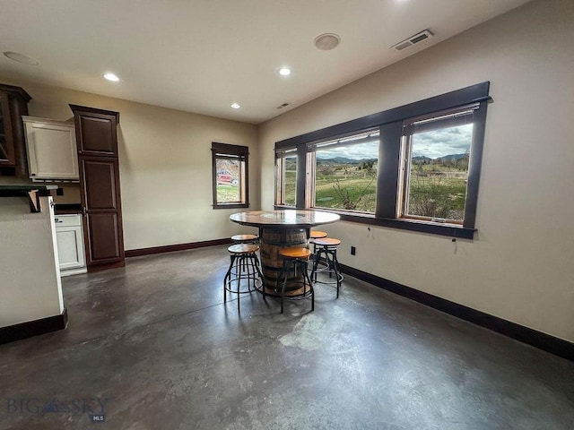 dining space featuring baseboards, visible vents, finished concrete flooring, and recessed lighting
