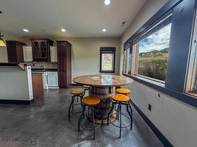 dining area with finished concrete floors, recessed lighting, and baseboards