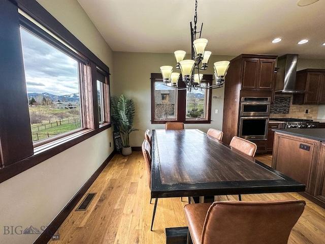 dining space featuring recessed lighting, a notable chandelier, visible vents, light wood-style flooring, and baseboards